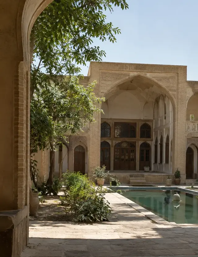 نمایی از حیاط سنتی با حوض و ایوان، از دل یک طاق